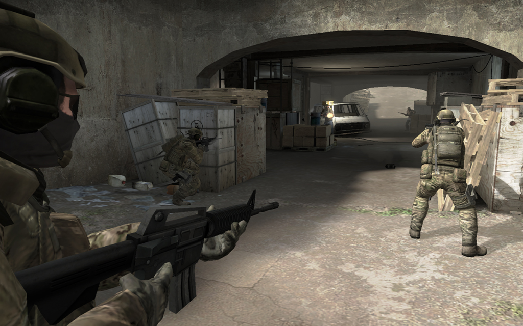 Tela do jogo Counter-Strike com três jogadores empunhando armas de fogo na entrada de uma cobertura, sendo esse um dos jogos FPS mais jogados da história.