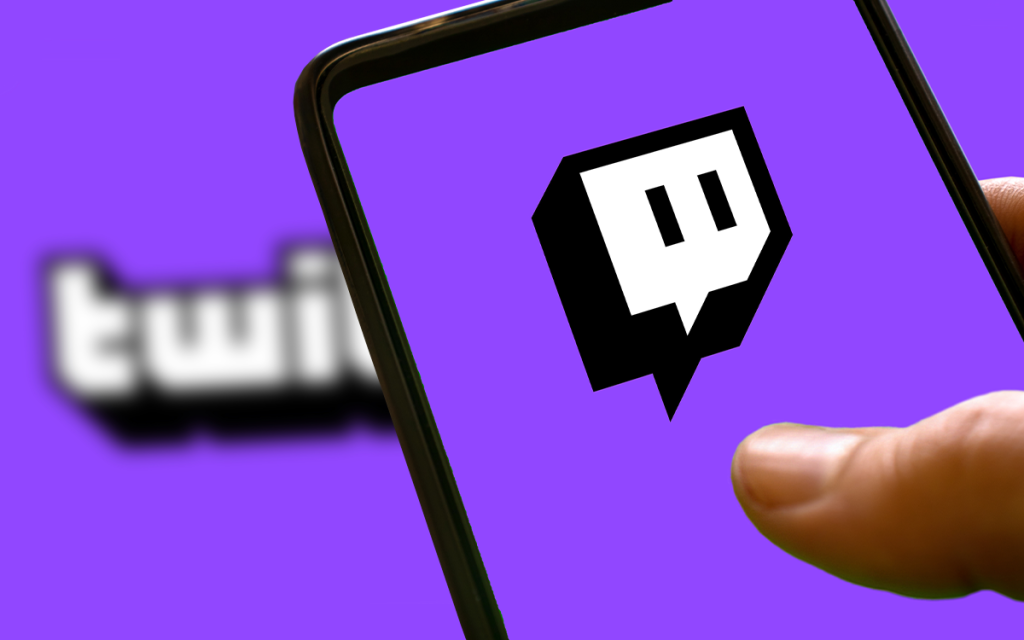 Mão segurando celular com o logo da Twitch.