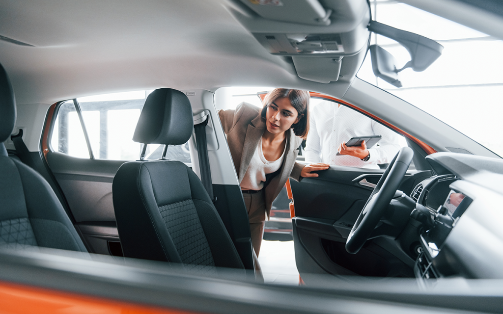 mulher entrando em carro em exposição dentro de concessionária sendo este um exemplo de ativação de marca em evento